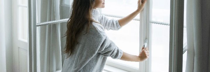 Frau schließt Fenster